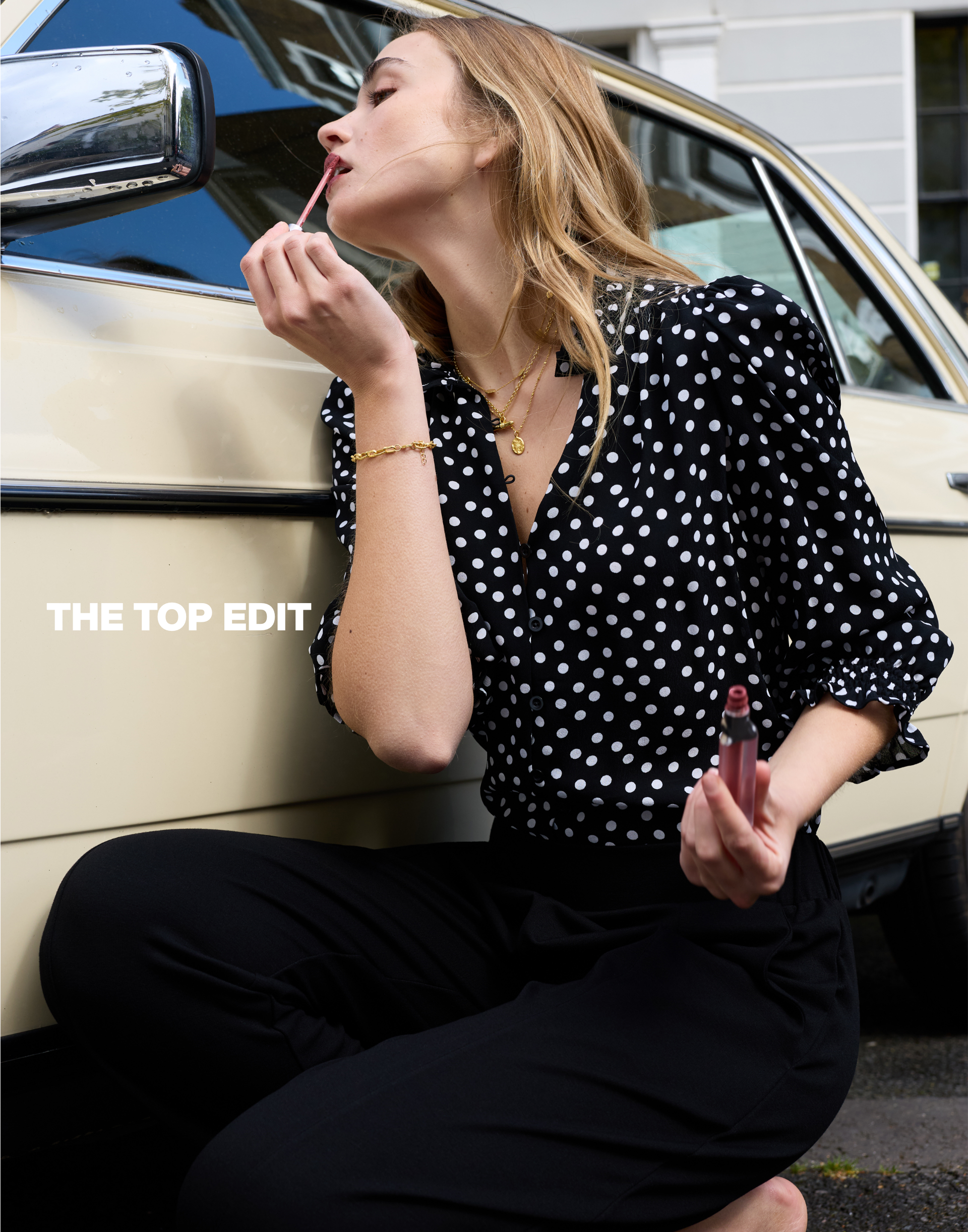 Woman wearing a lightweight black polka dot blouse from the Baukjen summer collection 